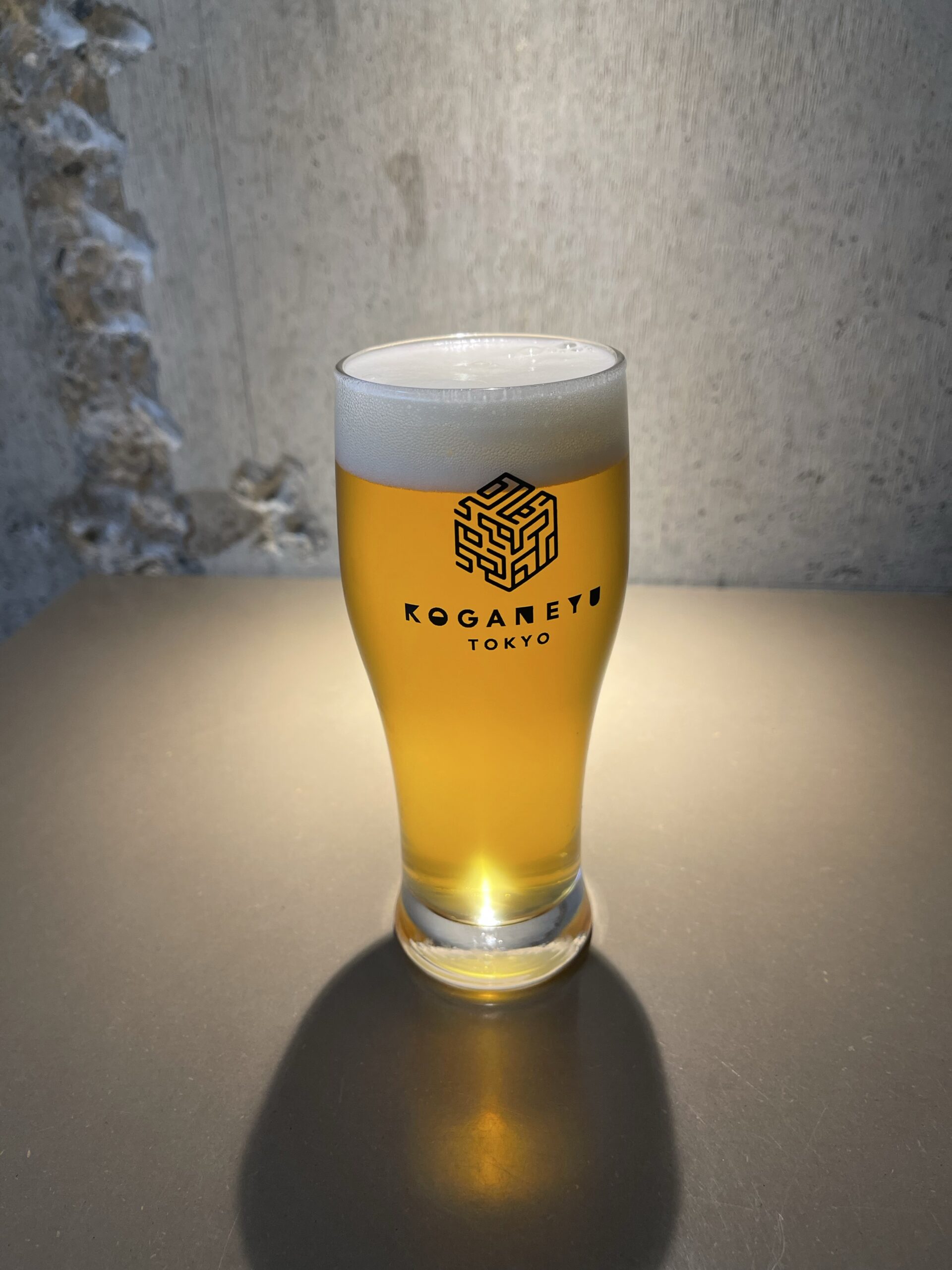 Glass of beer bearing the Koganeyu Tokyo logo